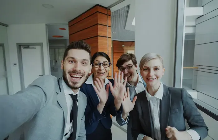 Diverse office team smiling and waving in a selfie, representing helpful support and listings on Local Biz Zone